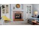 A cozy living space showcases a brick fireplace, custom built-ins, neutral decor, and comfortable seating at 10103 Knoll Cir, Highlands Ranch, CO 80130