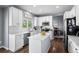 Bright kitchen includes white cabinets, a center island with seating, stainless appliances, and sleek countertops at 10103 Knoll Cir, Highlands Ranch, CO 80130