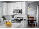 Updated kitchen with stainless steel appliances, tile backsplash, modern fixtures, and an adjacent dining area at 10103 Knoll Cir, Highlands Ranch, CO 80130