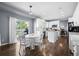Bright, open-concept kitchen with white cabinetry, center island, backyard access, and adjacent dining area at 10103 Knoll Cir, Highlands Ranch, CO 80130