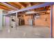 Unfinished basement with painted walls, exposed beams and laundry appliances at 12550 Maria Cir, Broomfield, CO 80020