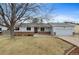 Charming single-story home with light blue siding, brick accents, mature trees and an attached garage at 12550 Maria Cir, Broomfield, CO 80020