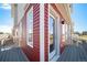 A close exterior view shows a red-paneled wall and a glass door leading to a deck at 13616 E 103Rd Pl, Commerce City, CO 80022