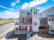 Two-story home with light-gray and red siding, and a double-balcony facade at 13616 E 103Rd Pl, Commerce City, CO 80022