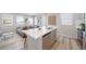 Open-concept living area with kitchen island, dining table, and comfortable living room setup at 13616 E 103Rd Pl, Commerce City, CO 80022