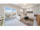 Bright living room with a large white sectional sofa and a sliding glass door to the outdoor balcony at 13616 E 103Rd Pl, Commerce City, CO 80022