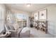 Bright and airy sitting room with a comfy chair, balcony access, and stylish shelving at 13616 E 103Rd Pl, Commerce City, CO 80022
