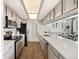 Well-lit kitchen features stainless steel appliances, sleek countertops, wood floors, and an open dining area at 4903 W 73Rd Ave, Westminster, CO 80030