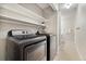 Convenient laundry room with modern washer and dryer, plus upper shelving for storage and organization at 4903 W 73Rd Ave, Westminster, CO 80030