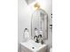 Stylish powder room featuring an arched mirror, modern vanity, and elegant black fixtures at 1561 W Beekman Pl, Denver, CO 80221