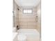 Updated bathroom showcasing a tiled shower and tub combination with a window at 1561 W Beekman Pl, Denver, CO 80221