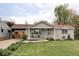 Charming home with a well-manicured front yard and covered front porch with seating area at 1561 W Beekman Pl, Denver, CO 80221