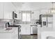 Stylish kitchen featuring white cabinets, stainless steel appliances, and a herringbone backsplash at 1561 W Beekman Pl, Denver, CO 80221