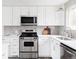 Well-equipped kitchen with stainless steel appliances, white cabinets, and modern finishes at 1561 W Beekman Pl, Denver, CO 80221