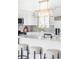 Bright kitchen with a central island, white cabinetry, and a modern light fixture at 1561 W Beekman Pl, Denver, CO 80221