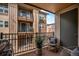 Cozy balcony space with outdoor seating, decorative plant, and a view of the building exterior at 15274 W 64Th Ln # 206, Arvada, CO 80007