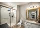 Bright bathroom featuring a walk-in shower with glass doors and a vanity with granite countertop at 15274 W 64Th Ln # 206, Arvada, CO 80007