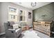 Charming Bedroom with a crib, reading chair, decorative wall, and large windows at 15274 W 64Th Ln # 206, Arvada, CO 80007