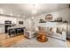 Open-concept living room featuring hardwood floors, a modern chandelier, and a large, comfortable sectional sofa at 15274 W 64Th Ln # 206, Arvada, CO 80007