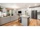 A well-lit living space features an island with seating and stainless steel appliances at 15274 W 64Th Ln # 206, Arvada, CO 80007