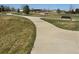 View of a park trail with benches, trees, and an open grassy area at 15274 W 64Th Ln # 206, Arvada, CO 80007
