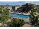 Community swimming pool area featuring lounge chairs, grilling station, pergola, and well maintained landscaping at 15274 W 64Th Ln # 206, Arvada, CO 80007
