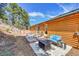 Backyard features a patio with fire pit, comfy seating, wood decking, and a hot tub, perfect for entertaining at 22349 Natsihi Rd, Indian Hills, CO 80454