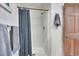 Shower area with blue patterned curtain, metal fixtures, and gray towels at 22349 Natsihi Rd, Indian Hills, CO 80454