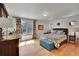 Cozy bedroom featuring a comfortable bed, wood floors, and a scenic window view at 22349 Natsihi Rd, Indian Hills, CO 80454