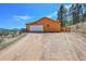 A bright, oversized garage featuring a large driveway and ample parking space with mountain views at 22349 Natsihi Rd, Indian Hills, CO 80454