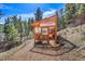 Charming wooden greenhouse nestled among the trees with a unique design and ample natural light at 22349 Natsihi Rd, Indian Hills, CO 80454