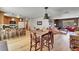 Open-concept living room with wood floors connecting the kitchen, dining area, and comfortable sitting area at 22349 Natsihi Rd, Indian Hills, CO 80454