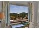 Scenic landscape view from the interior window; with a partial view of the table set and curtains at 22349 Natsihi Rd, Indian Hills, CO 80454