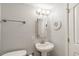 Well-lit bathroom featuring a pedestal sink, a round mirror, and white cabinets at 1151 N Marion St # 104, Denver, CO 80218