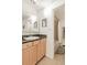 Bathroom with light wood cabinets, black countertop, and a shower with a white curtain in the background at 1151 N Marion St # 104, Denver, CO 80218