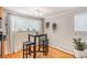 Bright dining area featuring wood floors, a stylish table with stools, and large windows for natural light at 1151 N Marion St # 104, Denver, CO 80218