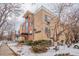 Three-story brick apartment building, 'The Marion', with awning and partial snow covered landscape and nearby street at 1151 N Marion St # 104, Denver, CO 80218
