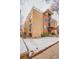 Three story brick apartment building with a partial snow covered yard and a small building to the right at 1151 N Marion St # 104, Denver, CO 80218