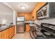 Functional kitchen featuring wooden cabinetry, stainless steel appliances, and granite countertops at 1151 N Marion St # 104, Denver, CO 80218
