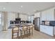 Bright kitchen featuring stainless steel appliances, a dark counter island with seating and light wood floors at 4110 Grand Lake St, Brighton, CO 80601