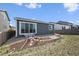 Landscaped backyard with a stone tile path leading to a sitting area and large sliding glass door at 95 S Edge Cliff St, Castle Rock, CO 80104