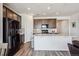Open kitchen featuring dark cabinets, stainless steel appliances, and a large central island at 95 S Edge Cliff St, Castle Rock, CO 80104