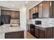 Modern kitchen featuring dark wood cabinetry, sleek appliances, and a stylish marble countertop at 95 S Edge Cliff St, Castle Rock, CO 80104