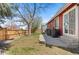 Fenced backyard with grassy area, concrete patio, grill, and mature tree at 944 E Lily Ct, Highlands Ranch, CO 80126