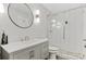 Modern bathroom featuring a glass-enclosed shower, sleek vanity, and a round mirror, designed for relaxation at 944 E Lily Ct, Highlands Ranch, CO 80126