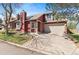 Charming two-story home with a red exterior, manicured lawn, and attached two-car garage at 944 E Lily Ct, Highlands Ranch, CO 80126