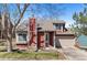 Charming two-story home with a red exterior, manicured lawn, and attached two-car garage at 944 E Lily Ct, Highlands Ranch, CO 80126