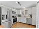 Modern kitchen with stainless steel appliances, white cabinets, and hardwood floors at 944 E Lily Ct, Highlands Ranch, CO 80126