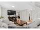 Cozy living room featuring comfortable seating, a large TV, and seamless access to dining area at 944 E Lily Ct, Highlands Ranch, CO 80126