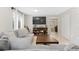 Comfortable living room with large sectional sofa, TV and shelving unit, neutral tones and tile flooring at 944 E Lily Ct, Highlands Ranch, CO 80126